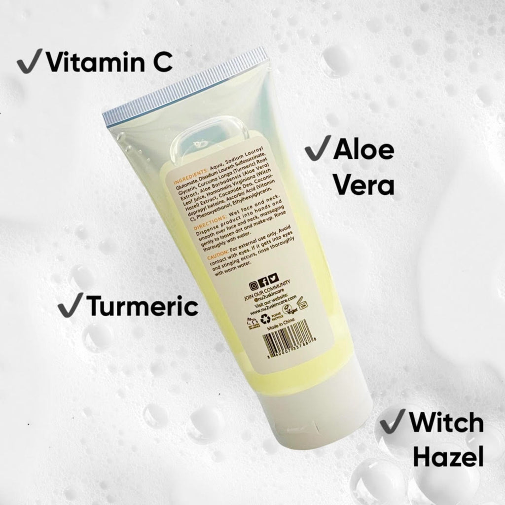 alt="Back of NU Face Gelly Cleanser tube showing ingredients, directions and caution laying on foam and bubbles with captions that say Vitamin C, Turmeric, Aloe Vera, and Witch Hazel." 